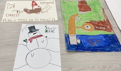 Three drawings done by children of a snowman, a boat, and an abstract.