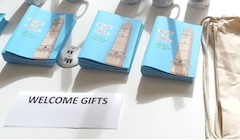 A table with a sign reading "welcome gifts" and booklets from Imperial College.