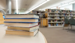 A stack of books on a table in a library.