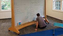 A man writes on a white board showing the "expressions of trust" graph.